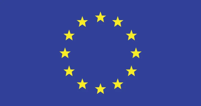Bandera europea ondeando con doce estrellas doradas sobre fondo azul